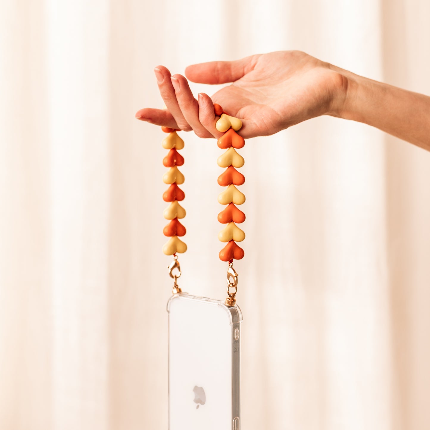 Phone case with orange & yellow hearts cord